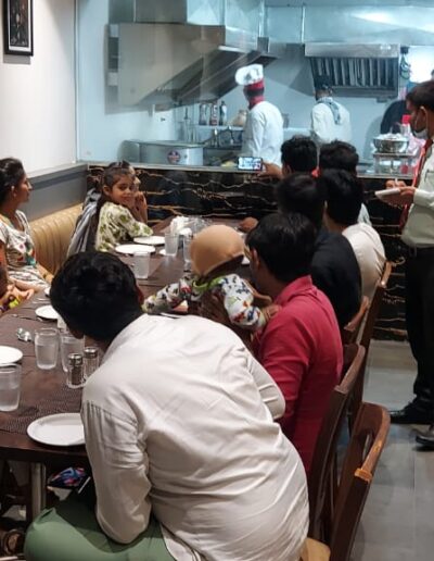 In this picture, you can see a transparent wall between the dine-in area and the kitchen area in Surat